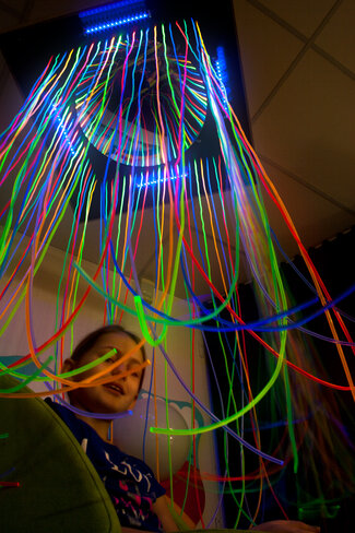 Douche fluoline, 90 x 90 x 180 cm Un îlot de détente entouré d'un rideau de fils fluorescents.